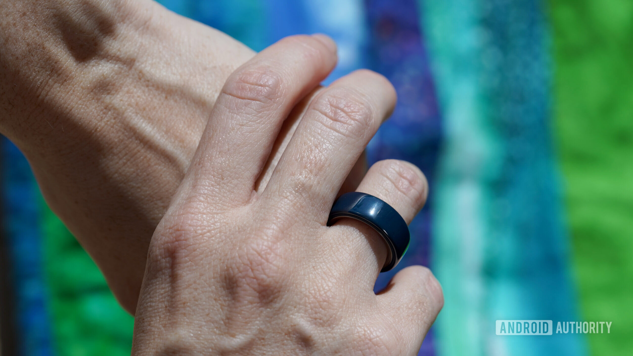 An Oura Ring user wears a ceramic model in Midnight.