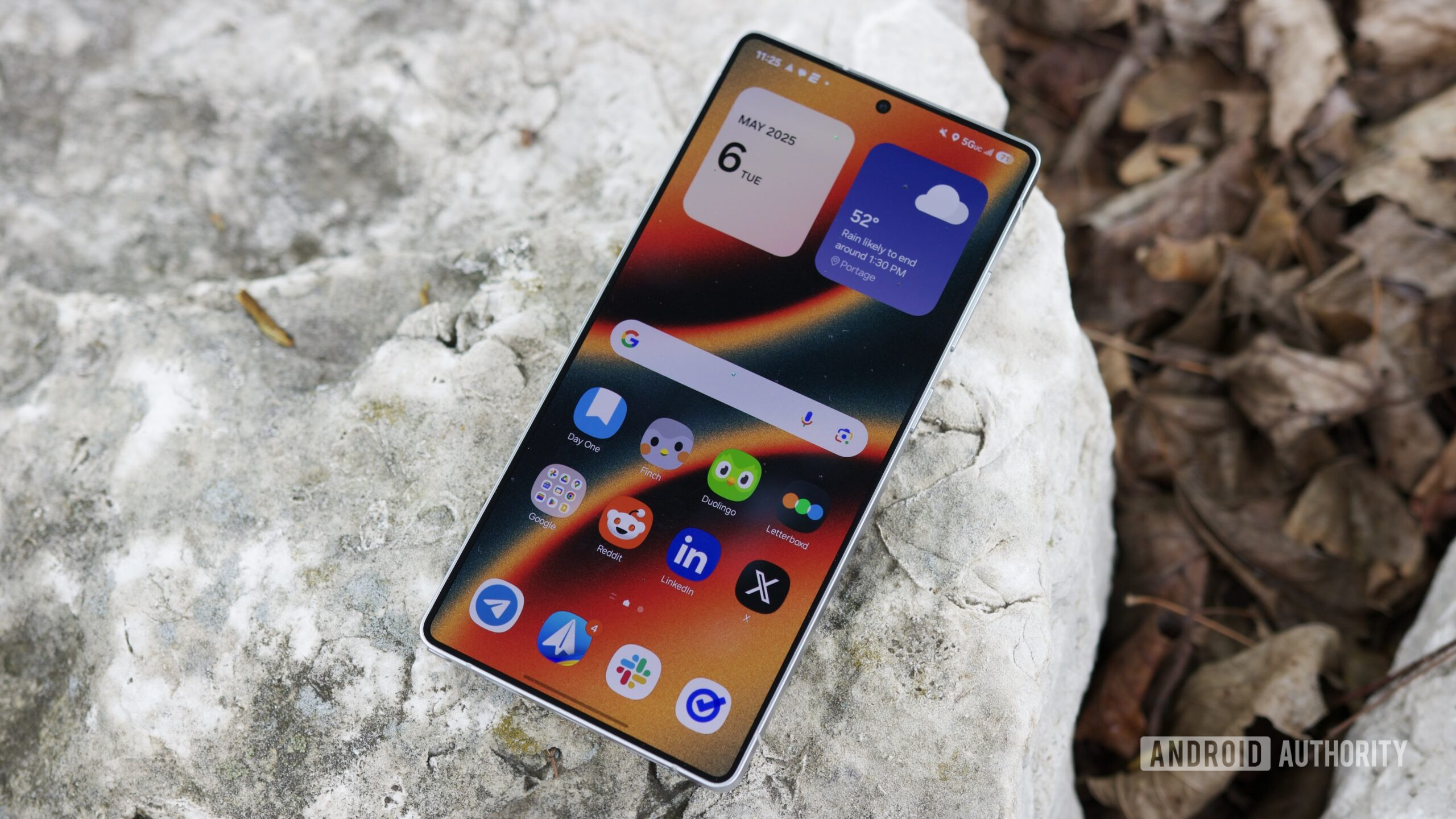 The Samsung Galaxy S25 Ultra laying outside with its display on.