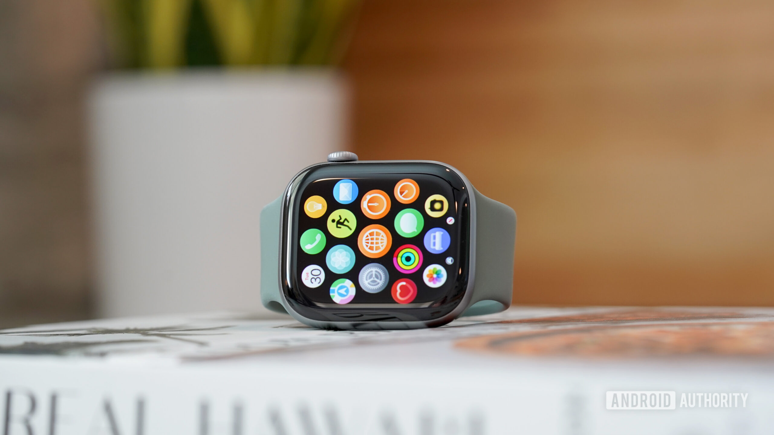 An Apple Watch Series 11 displays the updated app library.