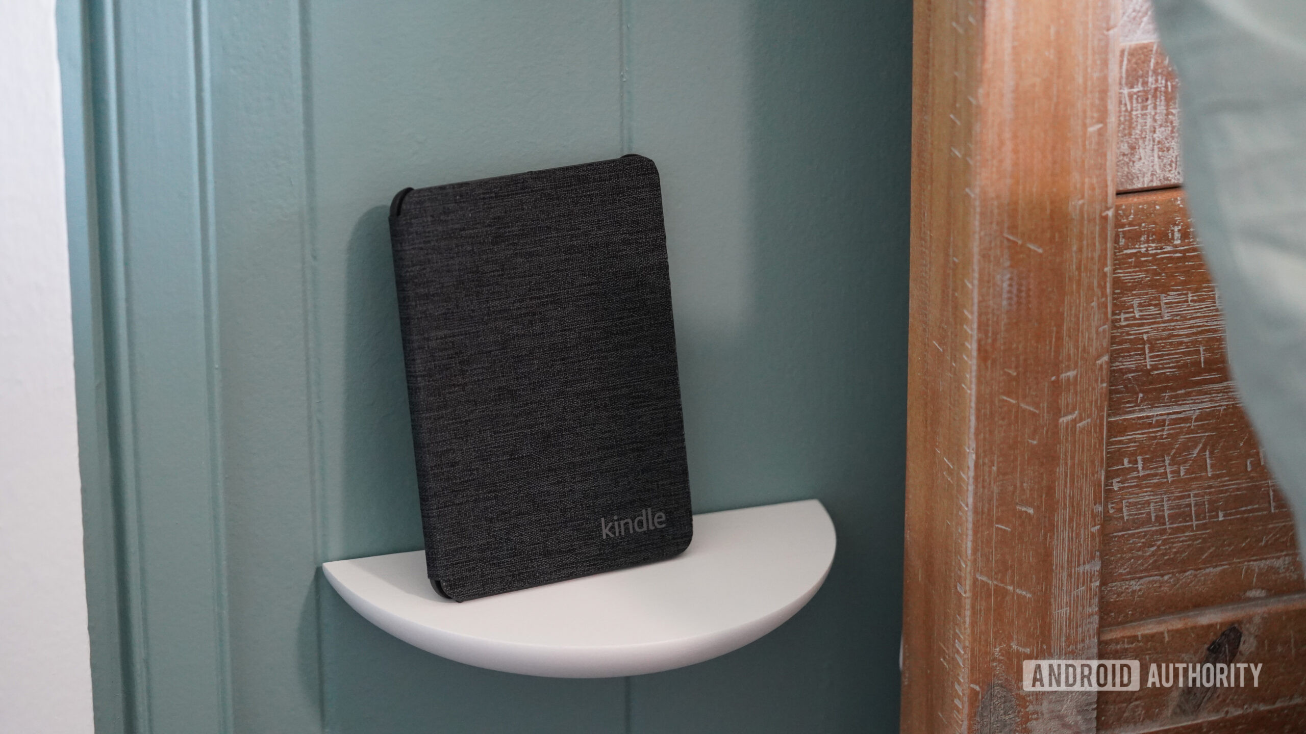 A Kindle rests on a small dedicated shelf.