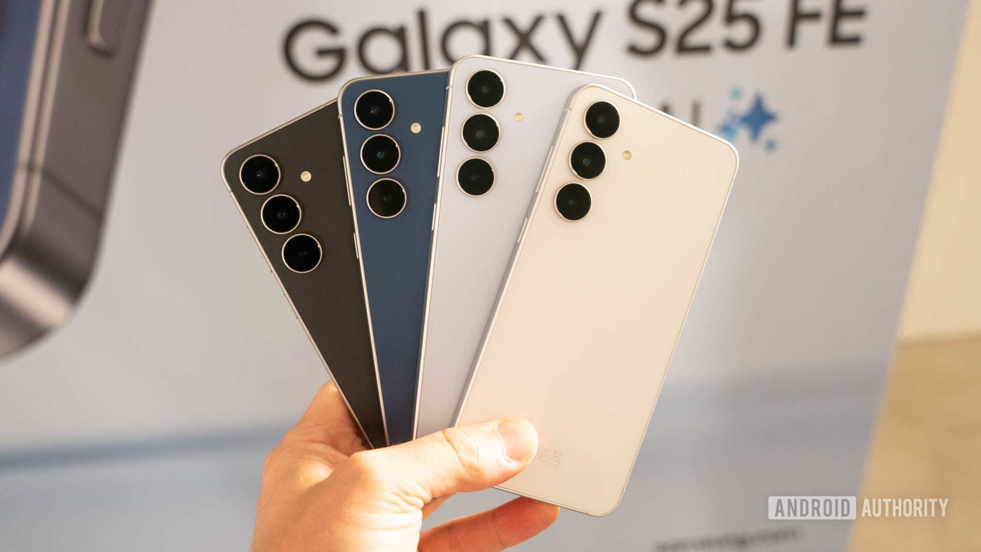 Samsung Galaxy S25 FE in all four colors fanned out in man's hand with logo behind it